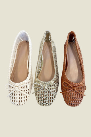 Three woven flats in white, gold, and brown on a light gray background