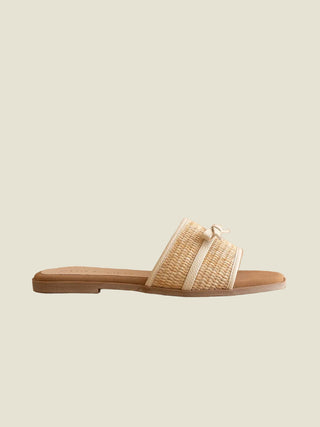 Woven sandal with a bow on a beige background