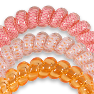 Close-up of pink and orange glass beads on a white background