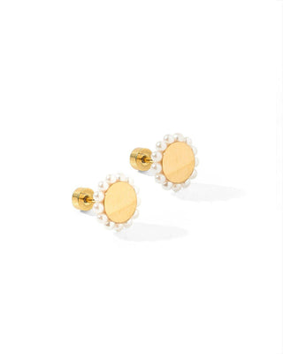 Gold earrings with pearl-like centers on a white background