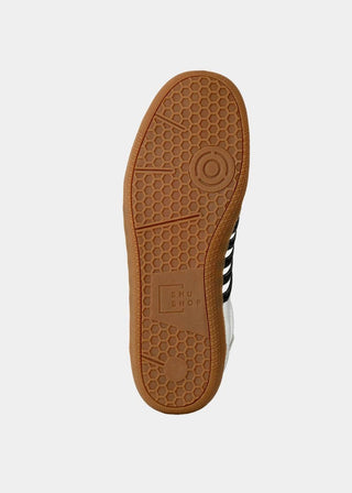 Sole of a sneaker with a brown sole and black and white stripes on a white background