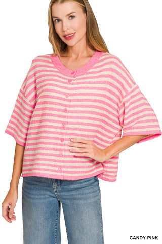 A woman wearing a pink and white striped short-sleeve cardigan top with a button-front closure, paired with blue jeans, against a plain white background.