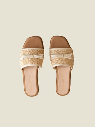 Pair of sandals with woven straps on a beige background