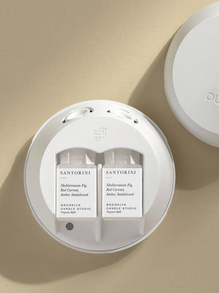 Two candles labeled 'Hawaii Rain' in a white container on a beige background
