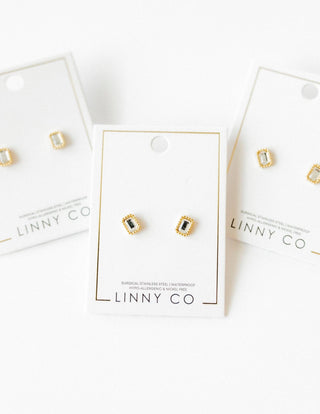 Gold and green gemstone earrings on LINNY CO branded cards against a white background