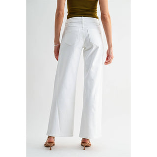 Person wearing white wide-leg pants on a plain background