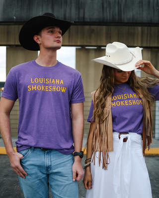 Two people wearing purple 'Louisiana Shokeshow' t-shirts outdoors.