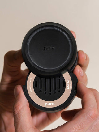 Pura car mount holder being held by a person with a neutral background