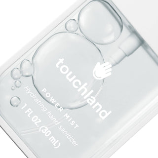 Touchland hand sanitizer bottle with droplets on a white background