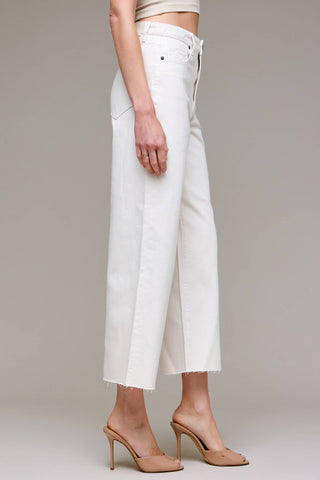 Person wearing white wide-leg pants on a plain background