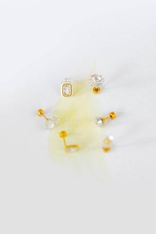 Set of gold and crystal earrings on a white background