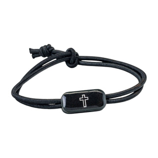 Black cord bracelet with a silver cross charm on a white background