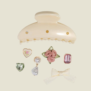 Cream-colored hair claw with decorative items on a light gray background