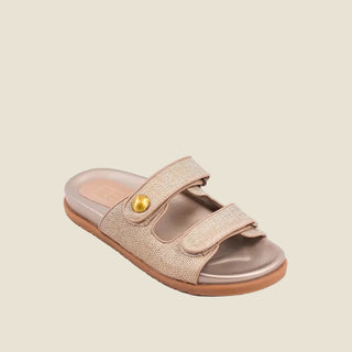 Beige sandal with a gold button on a light gray background