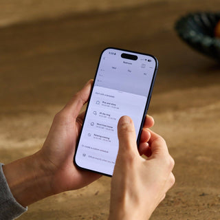 Person using a smartphone app on a blurred natural background