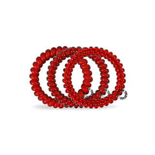 Red coil hair ties on a white background