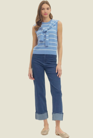 Woman wearing a striped top and blue jeans on a white background