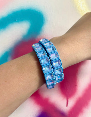 Blue beaded bracelet on a wrist with a colorful background