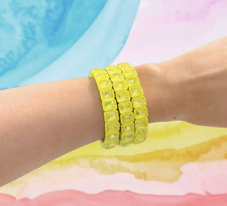 Yellow bracelet on a wrist with a colorful background