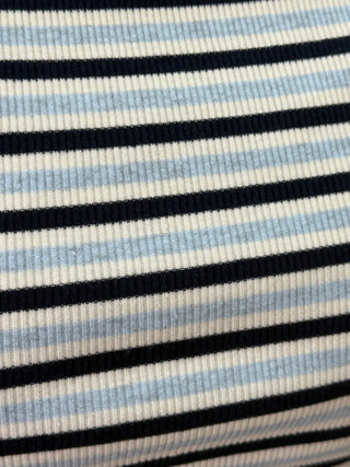 Close-up of a ribbed knit fabric with horizontal stripes in navy blue, light blue, and off-white.