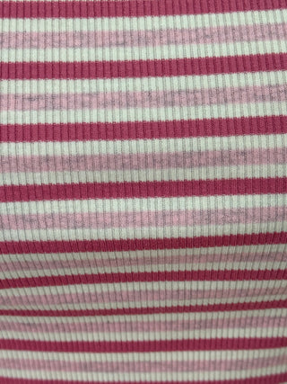 A close-up of a ribbed knit fabric with horizontal stripes in dark magenta and light pink on an off-white base.