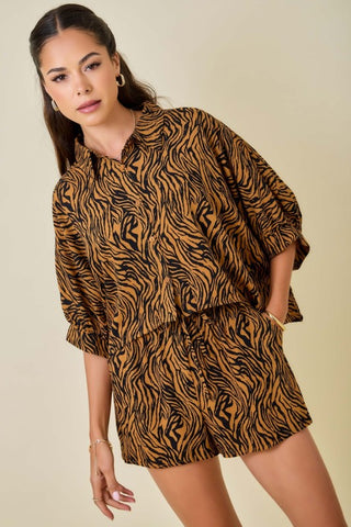 Woman wearing a tiger print outfit against a beige background