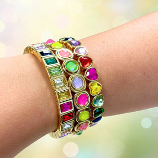 Multicolored gemstone bracelet on a wrist with a blurred light background