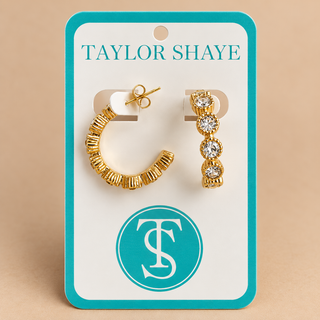 A pair of gold hoop and drop earrings displayed on a white jewelry card with a turquoise border. The card reads 'TAYLOR SHAYE' at the top and features a circular 'TS' logo near the bottom.