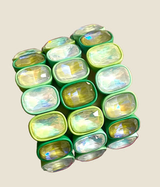 Green beaded bracelet on a wrist with a colorful background
