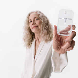 Person holding a small bottle labeled 'Trueand' against a white background