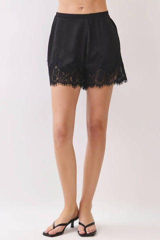 Black lace shorts worn by a person on a white background