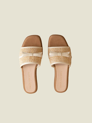 Pair of sandals with woven straps on a beige background