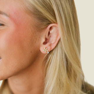 Close-up of a woman wearing a floral earring with a blurred background