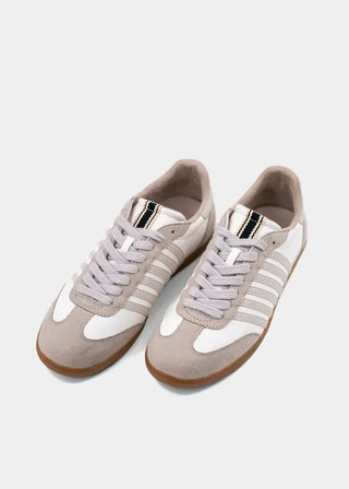 Pair of beige sneakers with white soles on a light gray background