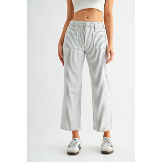 Person wearing white and gray striped pants on a plain background