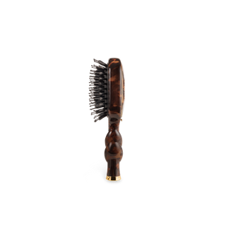 A single oval-shaped hairbrush shown from the side against a plain white background. The brush has a glossy dark brown tortoiseshell-patterned handle and head, black bristles, and a small gold-toned metal accent at the base.