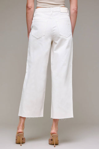 White wide-leg jeans worn by a person on a plain background