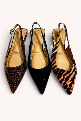 Three pointed slingback pumps with kitten heels are arranged side by side on a light gray background. The left shoe has a dark brown crocodile-embossed pattern, the middle shoe is solid black patent leather, and the right shoe features a brown and black tiger-stripe pattern.