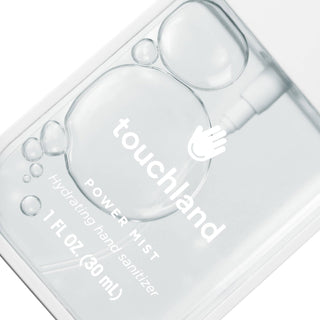 Touchland hand sanitizer bottle with droplets on a white background