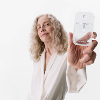 Person holding a small bottle labeled 'Trueand' against a white background