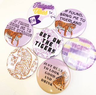 Collection of buttons with tiger-themed designs and text on a white background