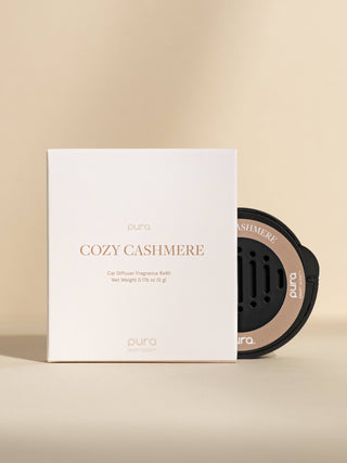 Pura Cozy Cashmere car diffuser fragrance ball with packaging on a beige background