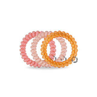 Set of three beaded bracelets in pink and orange on a white background