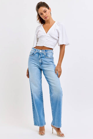 Woman wearing a white top and light blue jeans on a white background