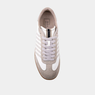 White sneaker with a gold accent on a white background