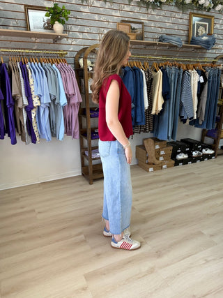 Side view of model wearing Cabernet colored sweater inside of a boutique