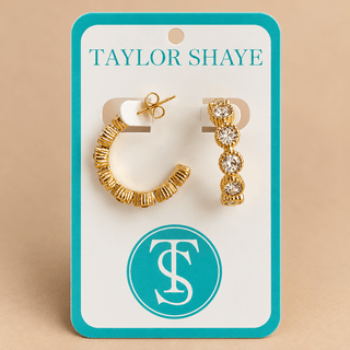 A pair of gold hoop and drop earrings displayed on a white jewelry card with a turquoise border. The card reads 'TAYLOR SHAYE' at the top and features a circular 'TS' logo near the bottom.