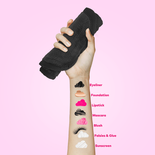 Hand holding black makeup remover pads with cosmetic icons on a pink background