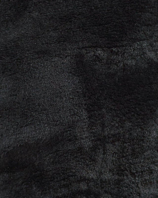 A close-up texture shot of a black shaggy faux fur fabric.