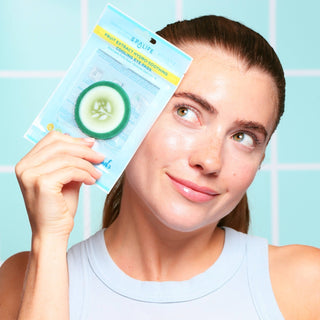 Woman holding a packaging of SPALIFE cucumber sheet mask against a light blue background